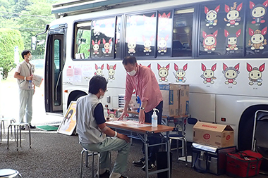山梨県赤十字血液センターの献血バス横で受付と問診を実施