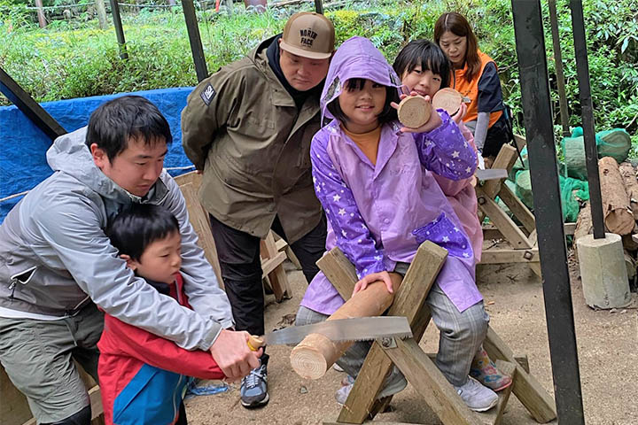 のこぎりを使って丸太切りを体験